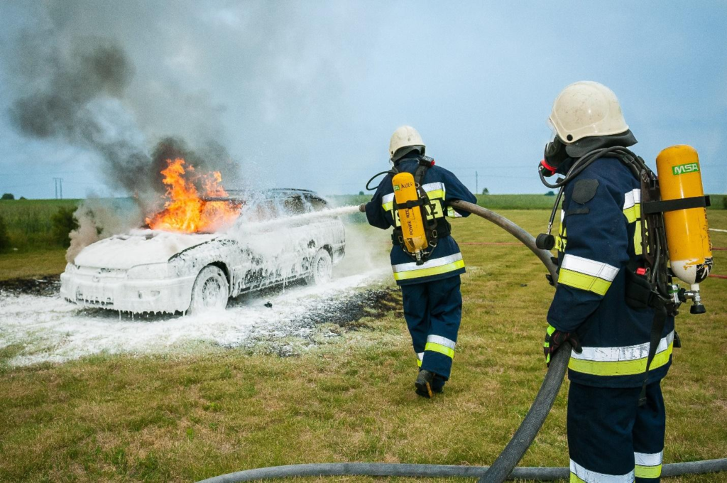 Firefighters putting out a fire on a car