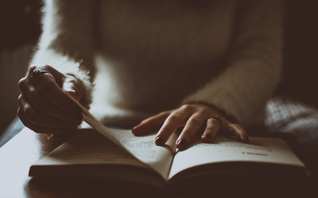 Person’s hands while turning book pages